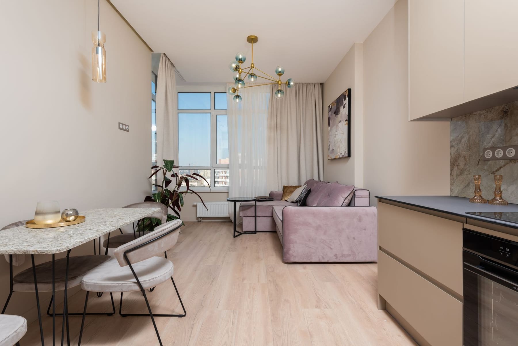 A bright, tidy small apartment living area with a sofa and window light