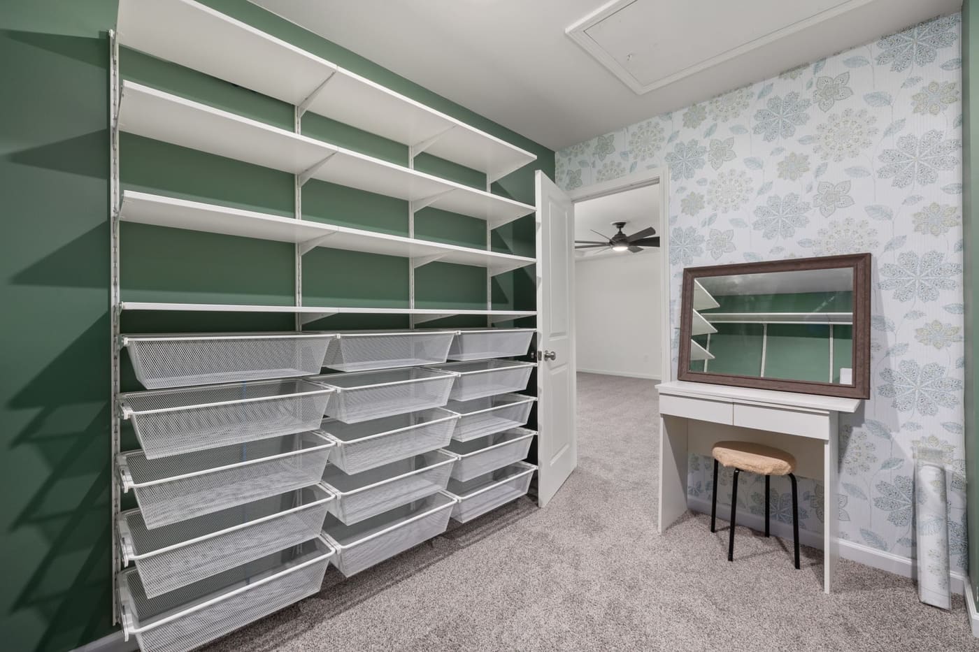A walk-in closet with built-in shelving and rows of white storage bins